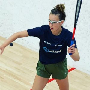 AJN Steelstock sponsored Emma Bartley about to hit the ball to serve in squash